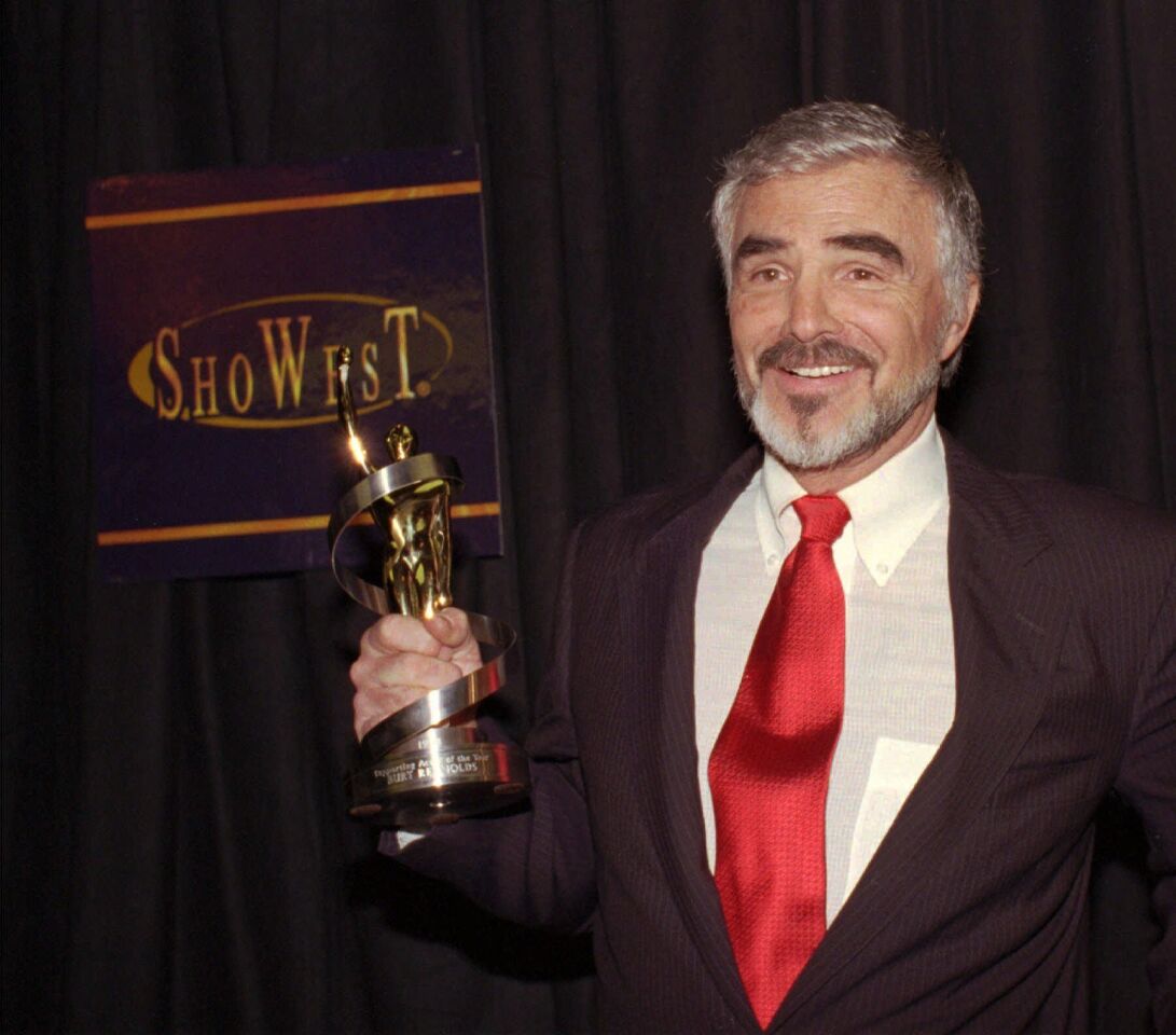 Burt Reynolds displays his Supporting Actor of the Year Award during the ShoWest Awards ceremony in Las Vegas on March 12, 1998.