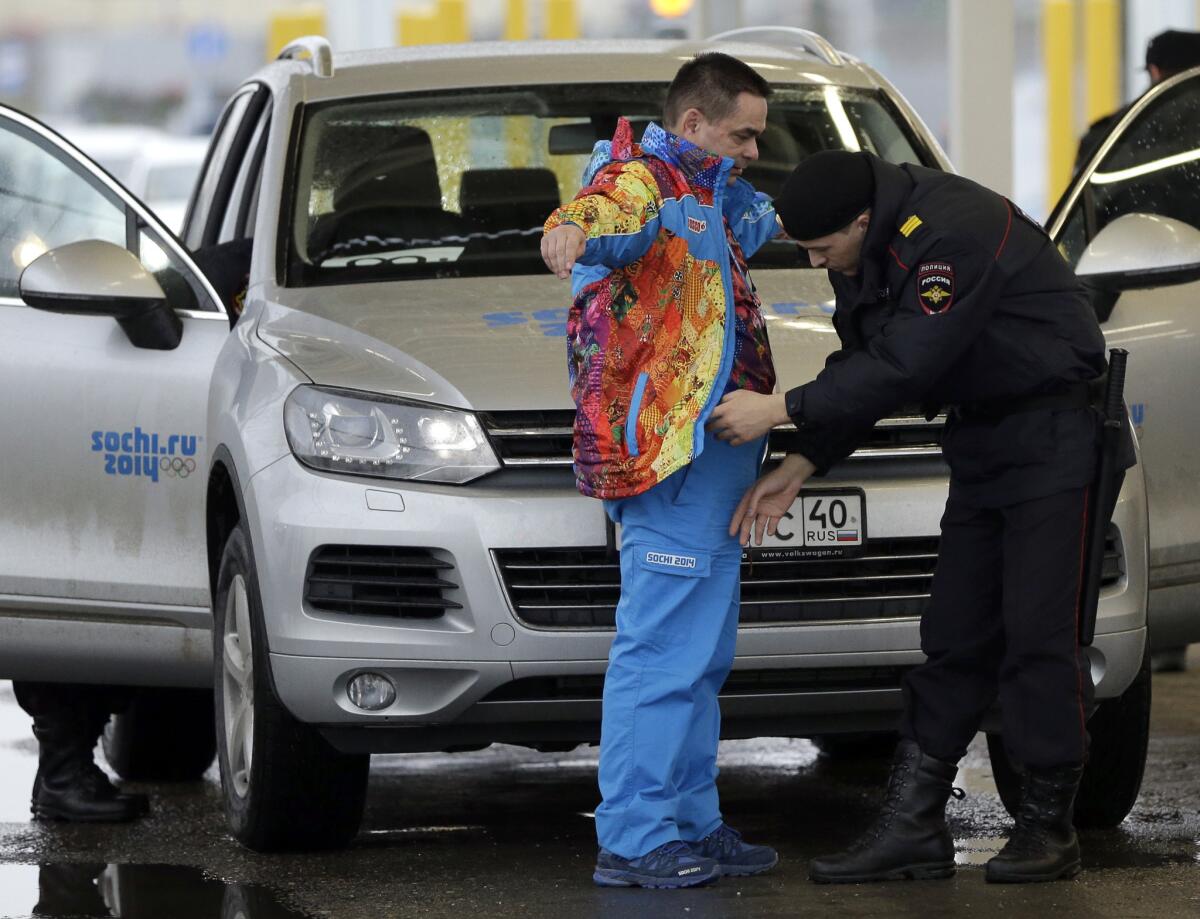 NBC executives said Thursday that they are comfortable with security efforts for the Winter Olympics. Above, a Russian police officer searches a driver as his vehicle is also screened at an entrance to the Sochi 2014 Olympic Winter Games park, Jan. 23, 2014, in Sochi, Russia.
