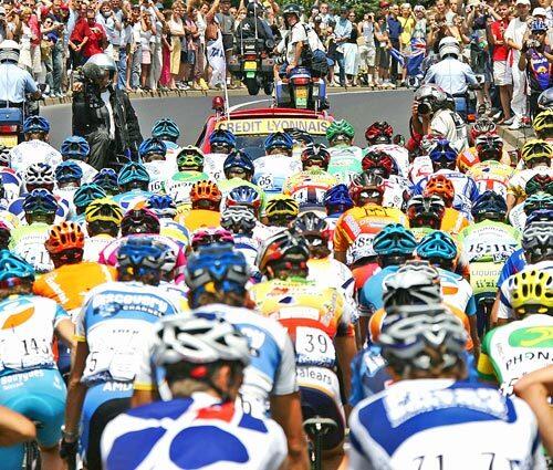 Photographers capture the pack taking off at the start of the 19th stage of the 92nd Tour de France.