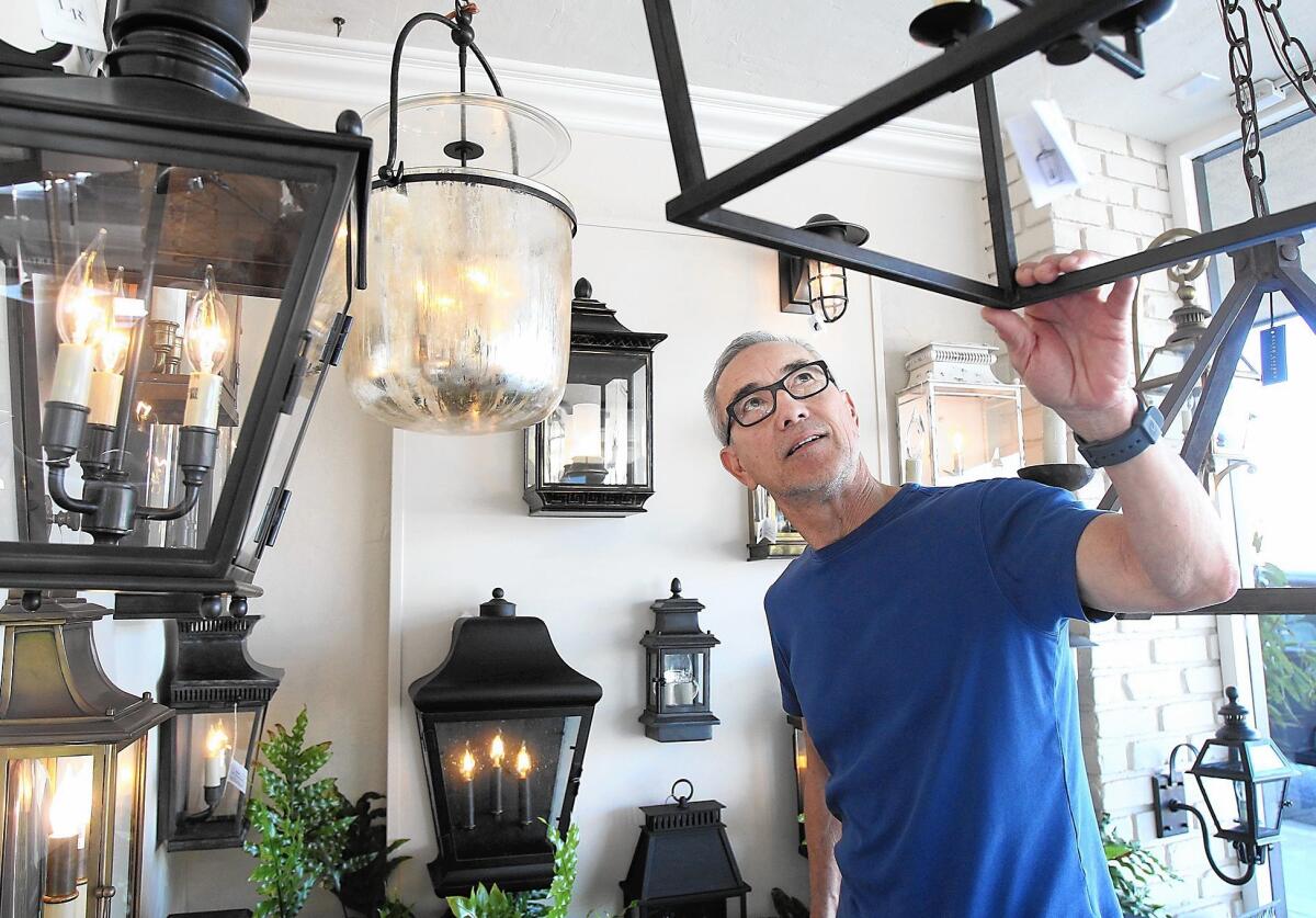 Sherwin Kim arranges and talks about the window display at the Linden Rose Lighting in Corona del Mar.