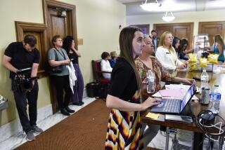 Rep. Zooey Zephyr, D-Missoula, works from the lunch counter outside House of Representatives chamber in the Montana State Capitol in Helena, Mont. on Monday, May 1, 2023. (Thom Bridge/Independent Record via AP)