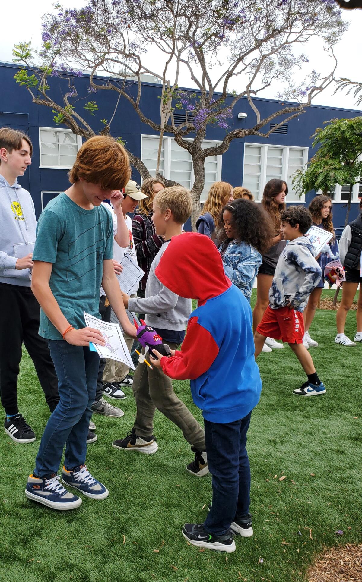 Muirlands Middle School students stand in line so La Jolla Elementary School students can find the monsters they designed.