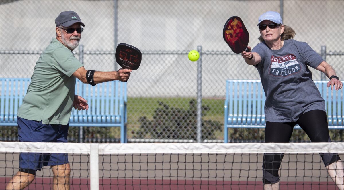 Two people play pickleball.