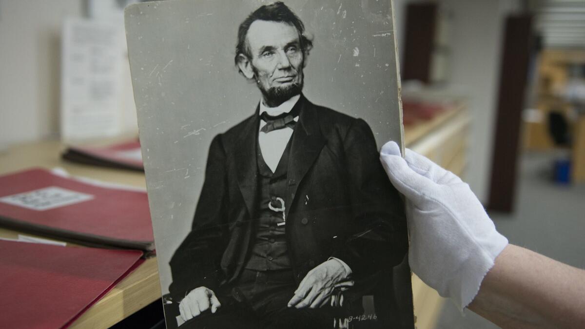 A woman holds a photograph of President Abraham Lincoln at the National Archives in College Park, Md. on April 6, 2015.