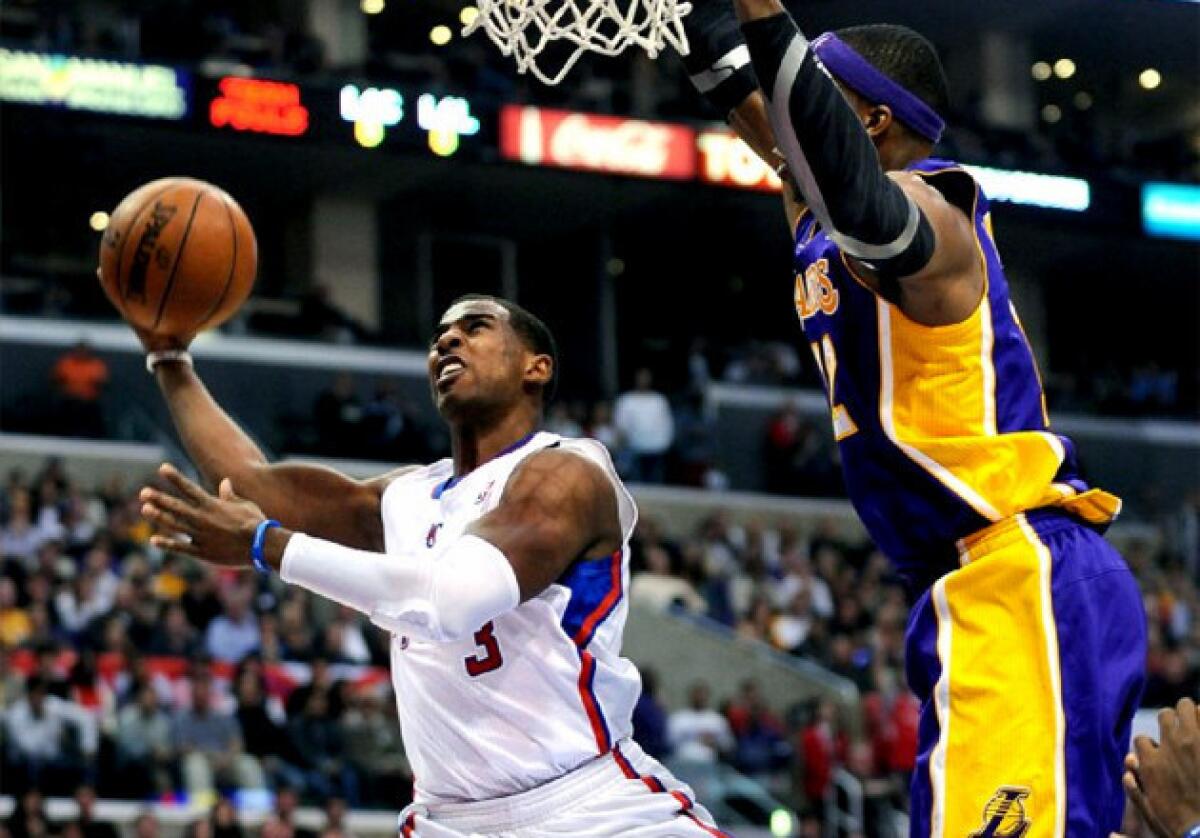 Clippers guard Chris Paul drives to the basket against Lakers' Dwight Howard.