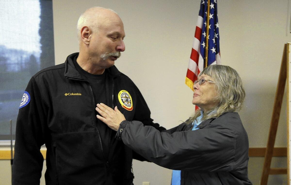 Snohomish County Sheriff's Office helicopter crew chief Randy Fay reunites in Arlington, Wash., with Robin Youngblood, whom he rescued from the roof of her home after the mudslide struck.