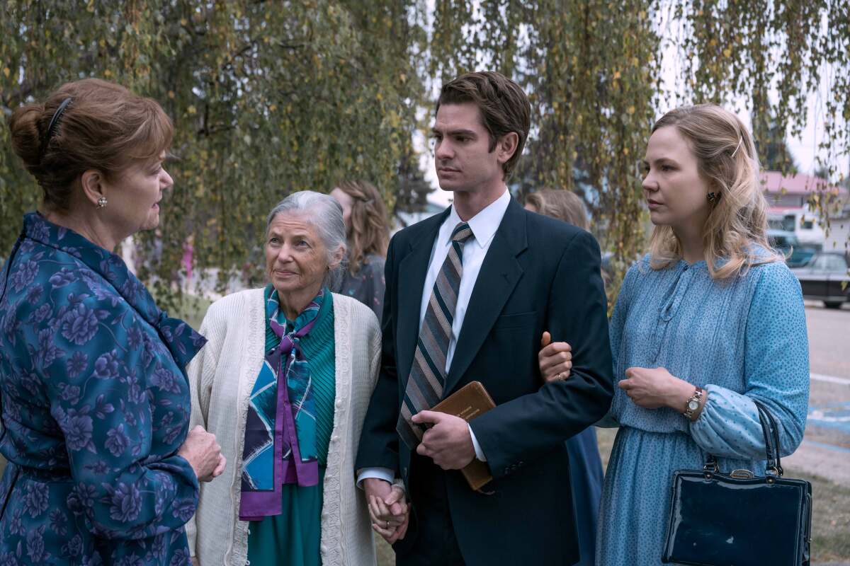 A man in a suit and three women standing outside