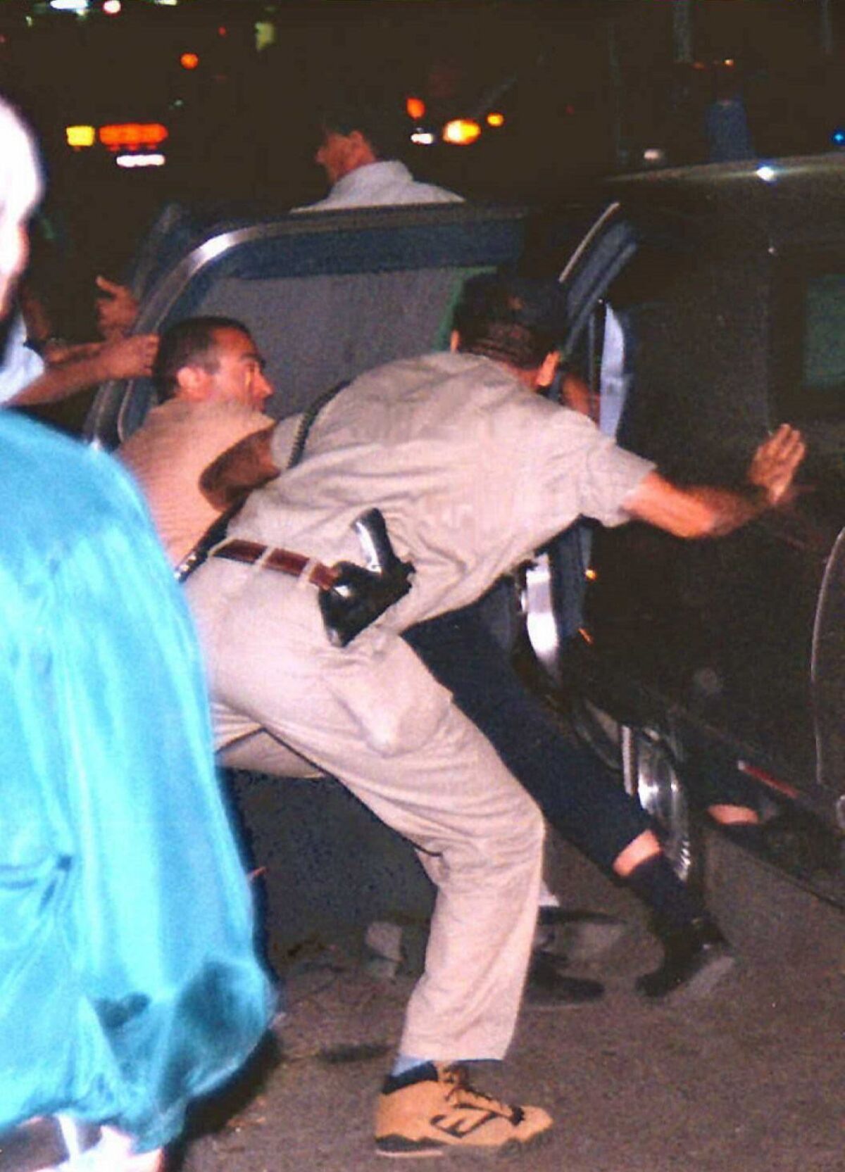 Israeli security personnel pushing Israeli Prime Minister Yitzhak Rabin into a car after he was shot an assassin in Tel Aviv on Nov. 4, 1995.