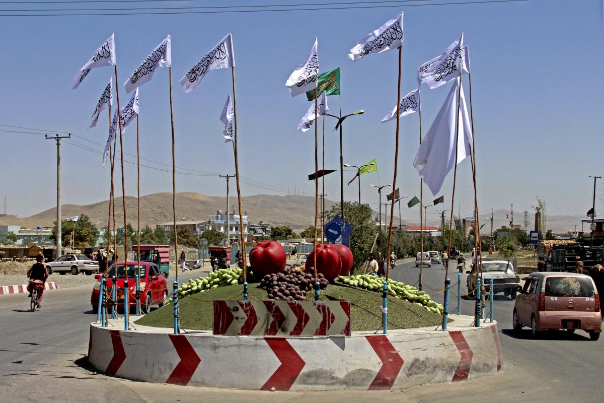 Taliban flags fly at a square 