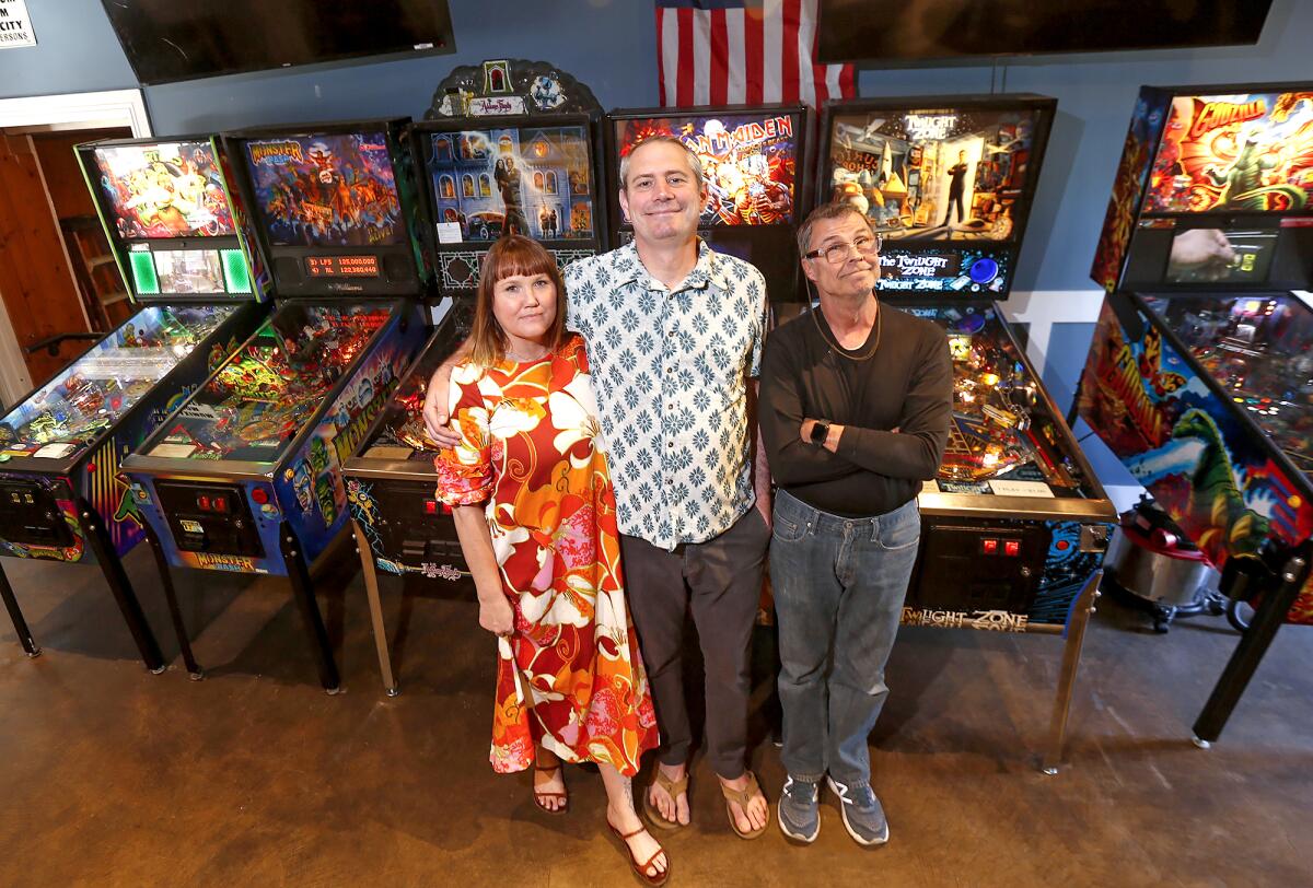 Organizers Jessica and Tom Walker along with pinball machine owner Pete Cooley.