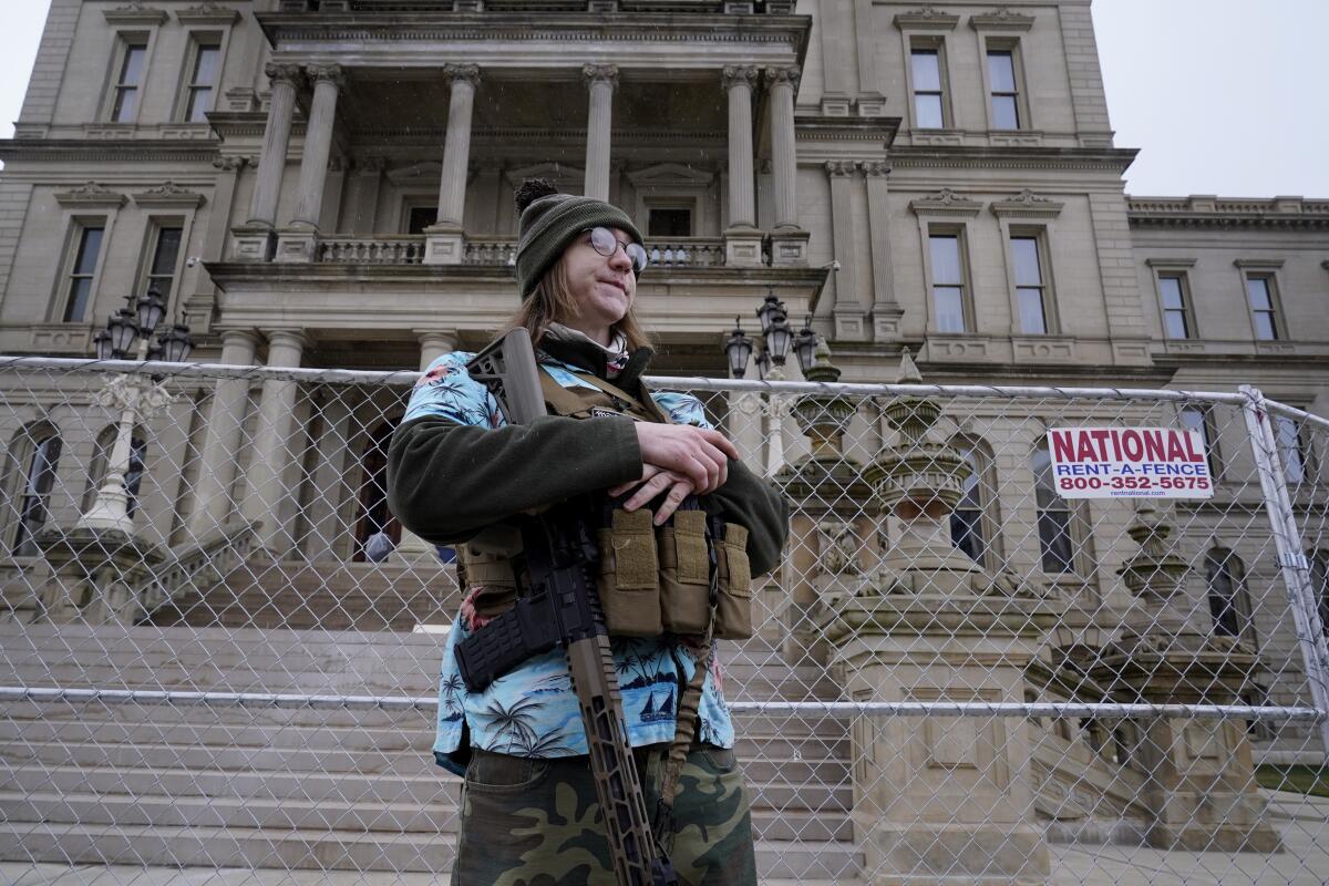 Far-right activist armed and in fatigues outside the state Capitol in Lansing, Mich.