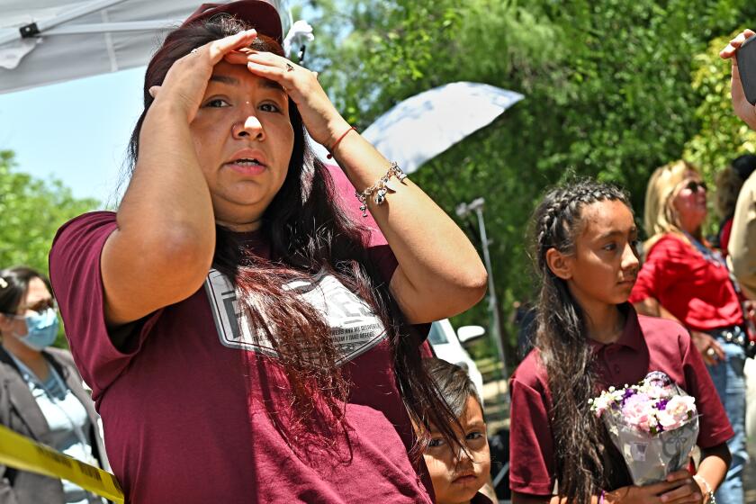 Uvalde, Texas May 25, 2022-A family who lost a child waits to be escorted by police outside Robb Elementary School in Uvalde, Texas Wednesday. (The family did notice any information other than they lost a child) (Wally Skalij/Los Angeles Times)