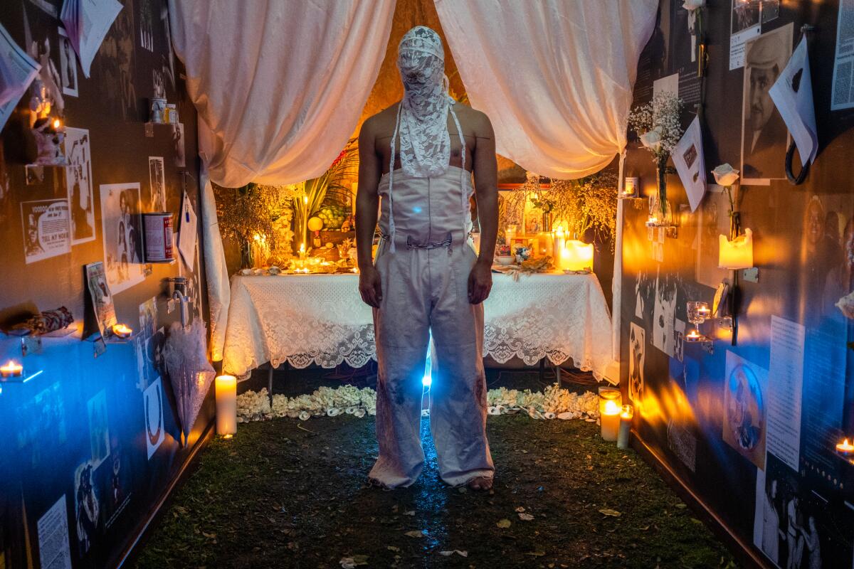 A man inside an installation beside a performance space. 