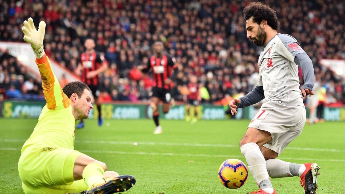 Liverpool's midfielder Mohamed Salah (R) dribbles the ball around Bournemouth's goalkeeper Asmir Begovic in the build-up to scoring his third goal in the game.