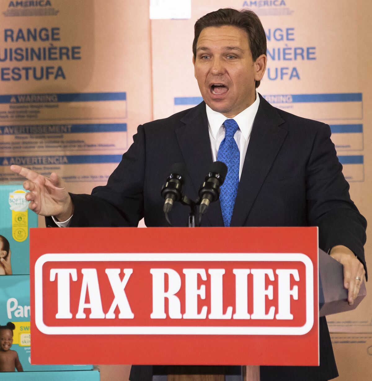 Florida Gov. Ron DeSantis speaks during a news conference behind a sign saying Tax Relief.