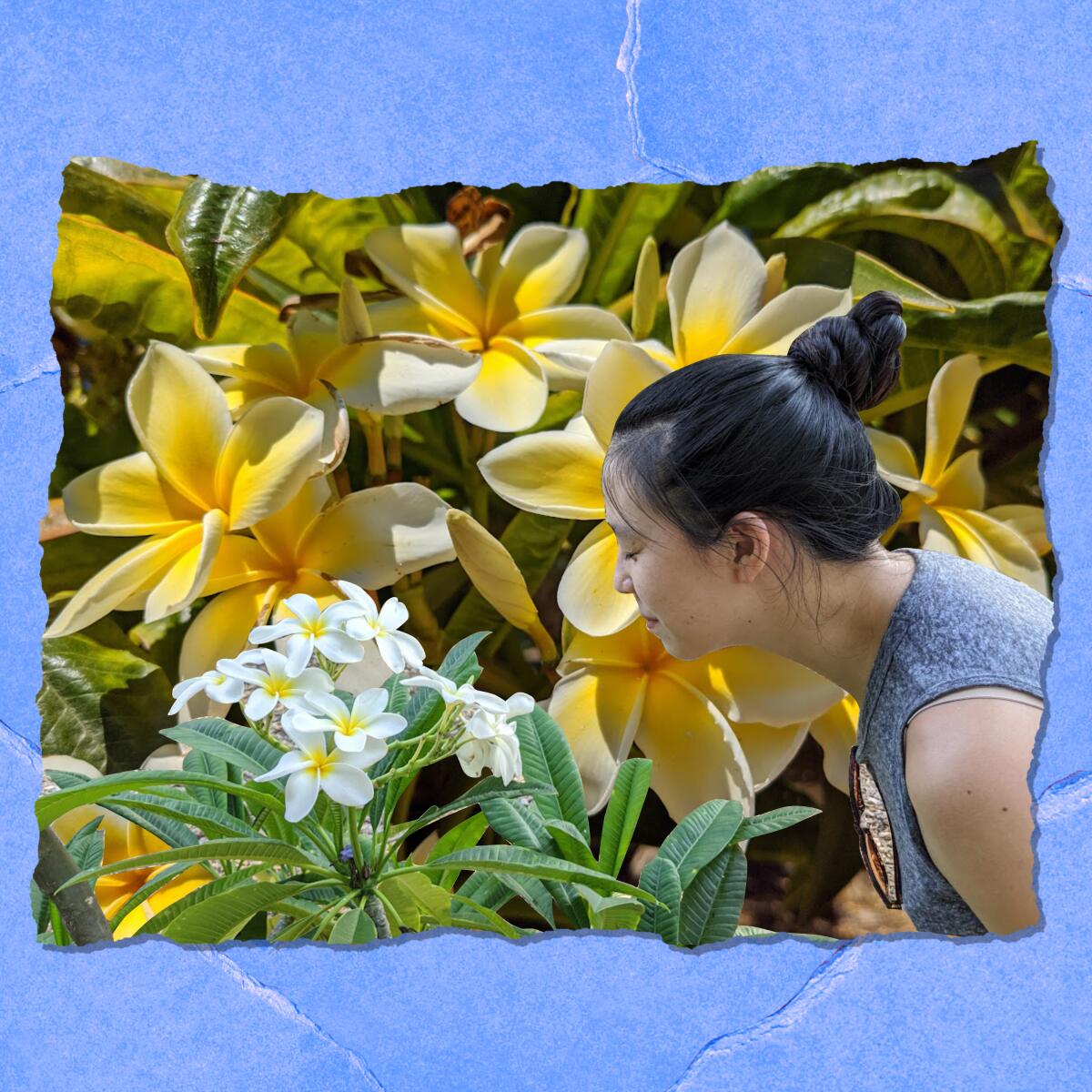 A woman leans over to smell flowers amid a thicket of blooms.