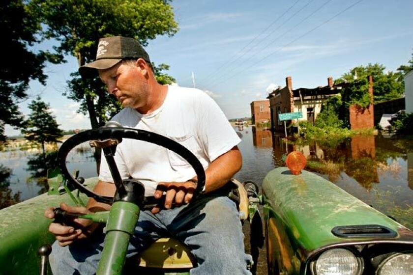 Bill Hunter drives his tractor through the floodwaters in Annada, Mo. His family owns 1,000 acres that are now under water. "We went from drought to this," Hunter said. "it's a mess."