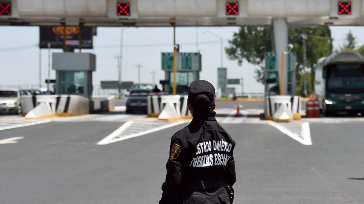 Un miembro de las fuerzas especiales mexicanas se encuentra parado frente a una barrera de peaje colocada cerca de la cárcel del Altiplano en Almoloya de Juárez, México, el 13 de julio.