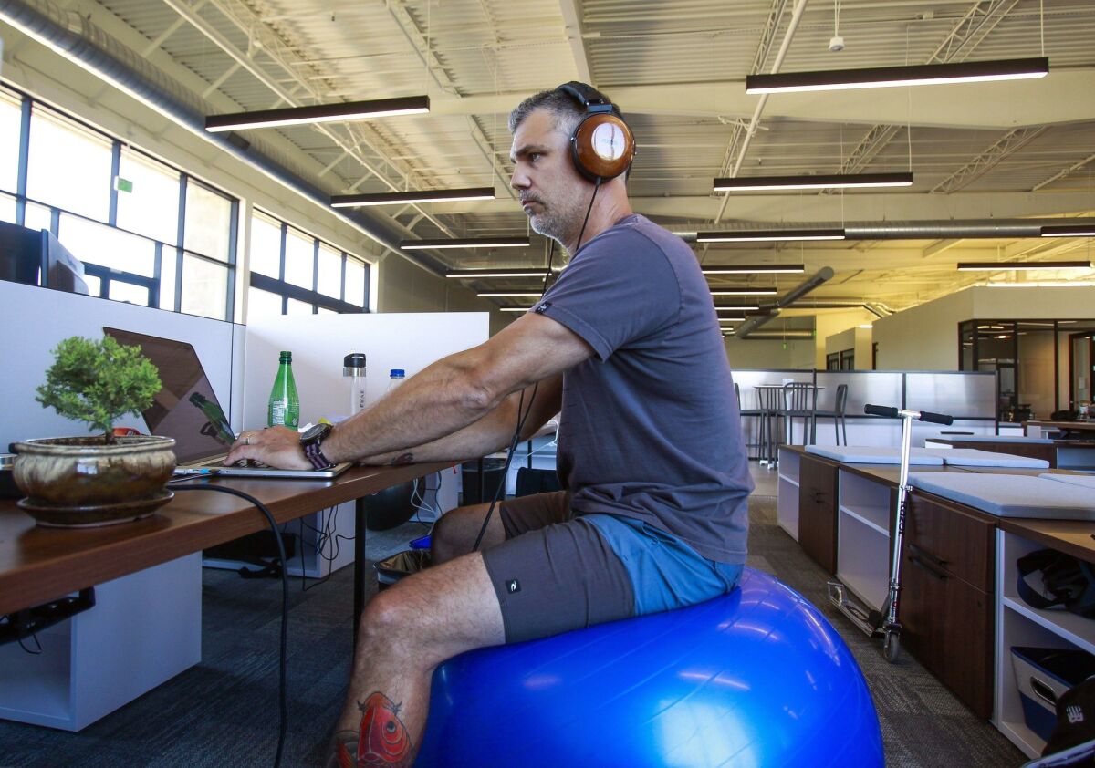 Trey King, who works in technical operations at Verve Mobile, works at his desk at Verve Mobile at the make multi-tenant office campus in Carlsbad on Wednesday. — Hayne Palmour IV