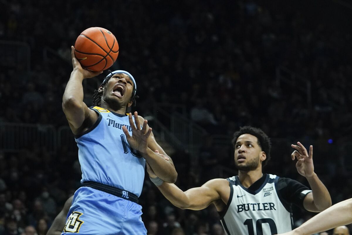Marquette's Justin Lewis, left, is fouled by Butler's Bryce Nze, right, during the second half of an NCAA college basketball game, Saturday, Feb. 12, 2022, in Indianapolis. (AP Photo/Darron Cummings)