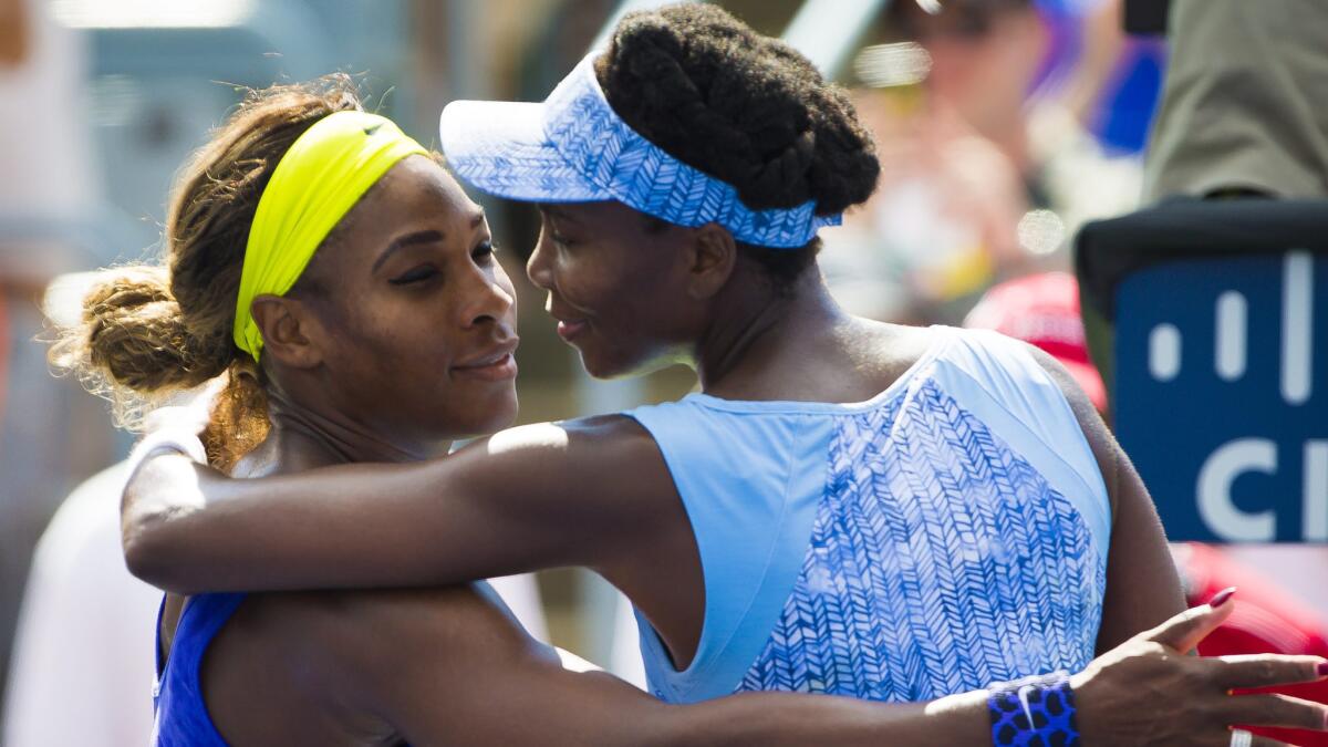 Venus Williams, right, is congratulated by her sister, Serena, following her semifinal victory at the Rogers Cup on Saturday.