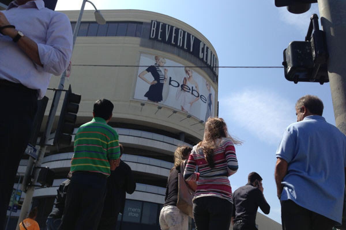 People look on after an evacuation of the Beverly Center in Los Angeles due to a suspicious package report.