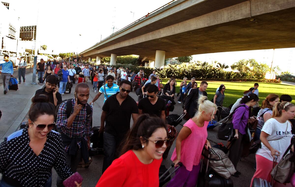 After hours of waiting, travelers stream back into LAX to make their flights, which had been delayed when a gunman began shooting inside the airport Nov. 1.