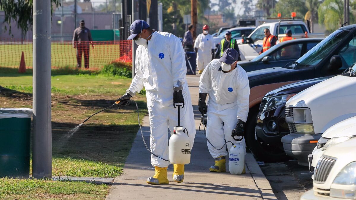 Work crews spray a bleach solution at North Park Community Park on Oct. 13, 2017, as part of the battle against a hepatitis A outbreak in San Diego.