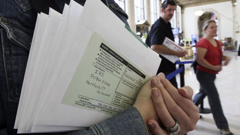 A woman holds her tax documents at the James A. Farley Post Office in New York, on April 15, 2010.