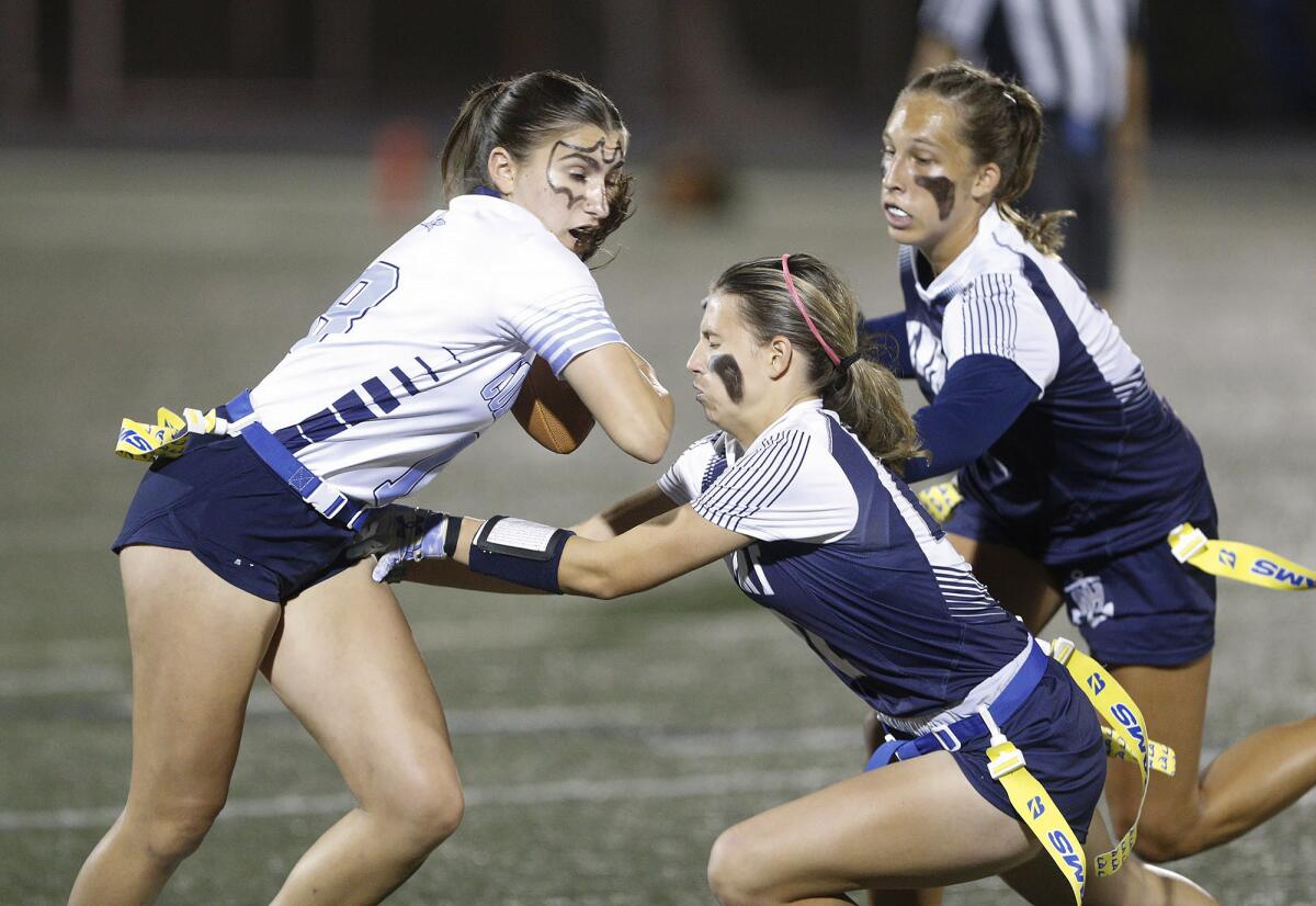 A Corona del Mar player tries to side-step Newport Harbor defenders Audrey Burns and Kate Kubiak.