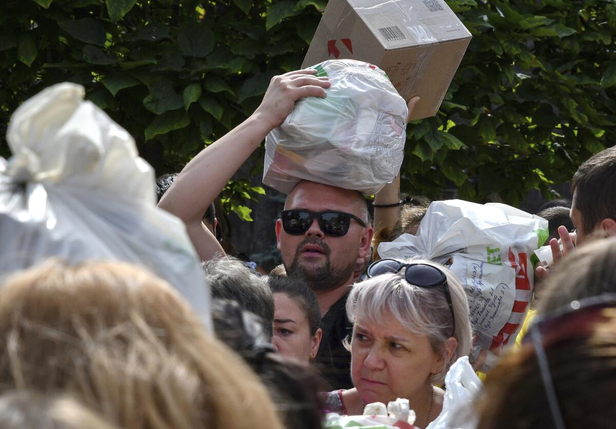 People gather to hand out donated items such as medicines, clothes and personal belongings to their relatives.