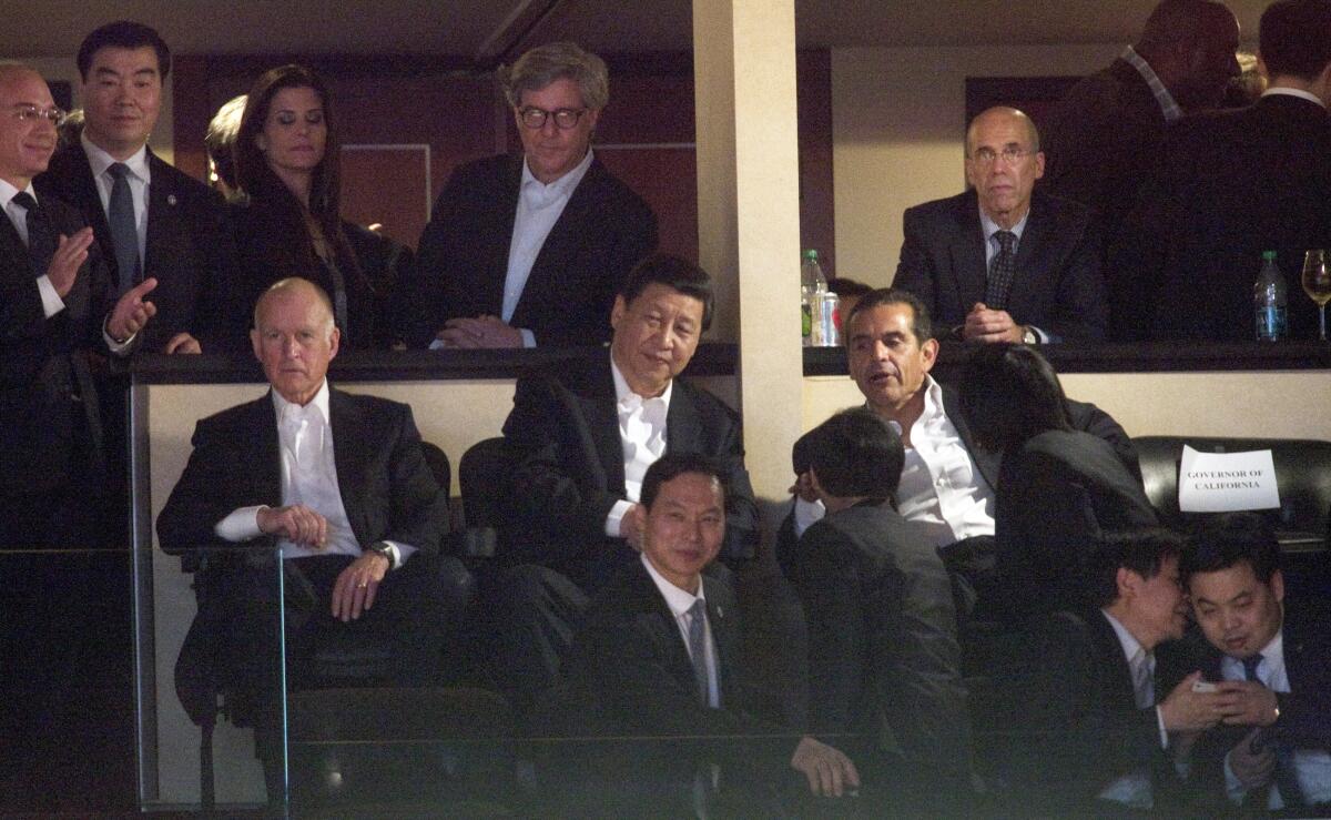 Xi Jinping, then the vice president of China, speaks with then-Los Angeles Mayor Antonio Villaraigosa while Jerry Brown, then governor of California, watches a game between the Lakers and the Suns at Staples Center in 2012. At top right is Jeffrey Katzenberg, then-CEO of DreamWorks Animation, who used his ties to California politicians — and to then-Vice President Joe Biden — to lobby Xi for access to the Chinese market.
