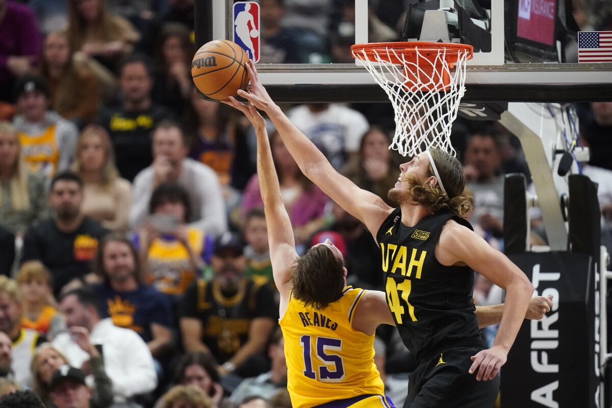 Utah Jazz's Kelly Olynyk (right) blocks a shot by Lakers' Austin Reaves Monday night.