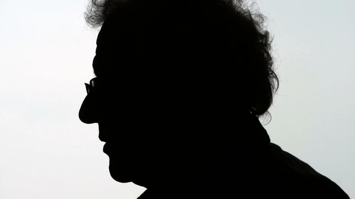 A man sits silhouetted in profile.