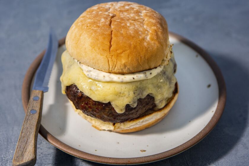 LOS ANGELES, CA--JUNE 13, 2019--A dry-aged burger with gruyere, homemade mayonnaise and potato bun, adapted from Katie Flannery, at Flannery Beef, photographed on a Los Angeles, CA, rooftop, June 13, 2019, as part of a "best beef to grill on fourth of July." Selections that were part of a "best beef to grill on the fourth of July": Aged ribeye steak with pistachio gremolata and charred balsamic broccolini (from Vartan Abgaryan at Yours Truly in Venice), Prime hangar steak with szechuan spices and citrus (from chef Brandon Kida, at Hinoki & the Bird in Century City), dry-aged burger with gruyere and homemade mayonnaise (adapted from Katie Flannery, at Flannery Beef) and skirt steak with marjoram and lime salsa, from writer Ben Mims. (Jay L. Clendenin / Los Angeles Times)