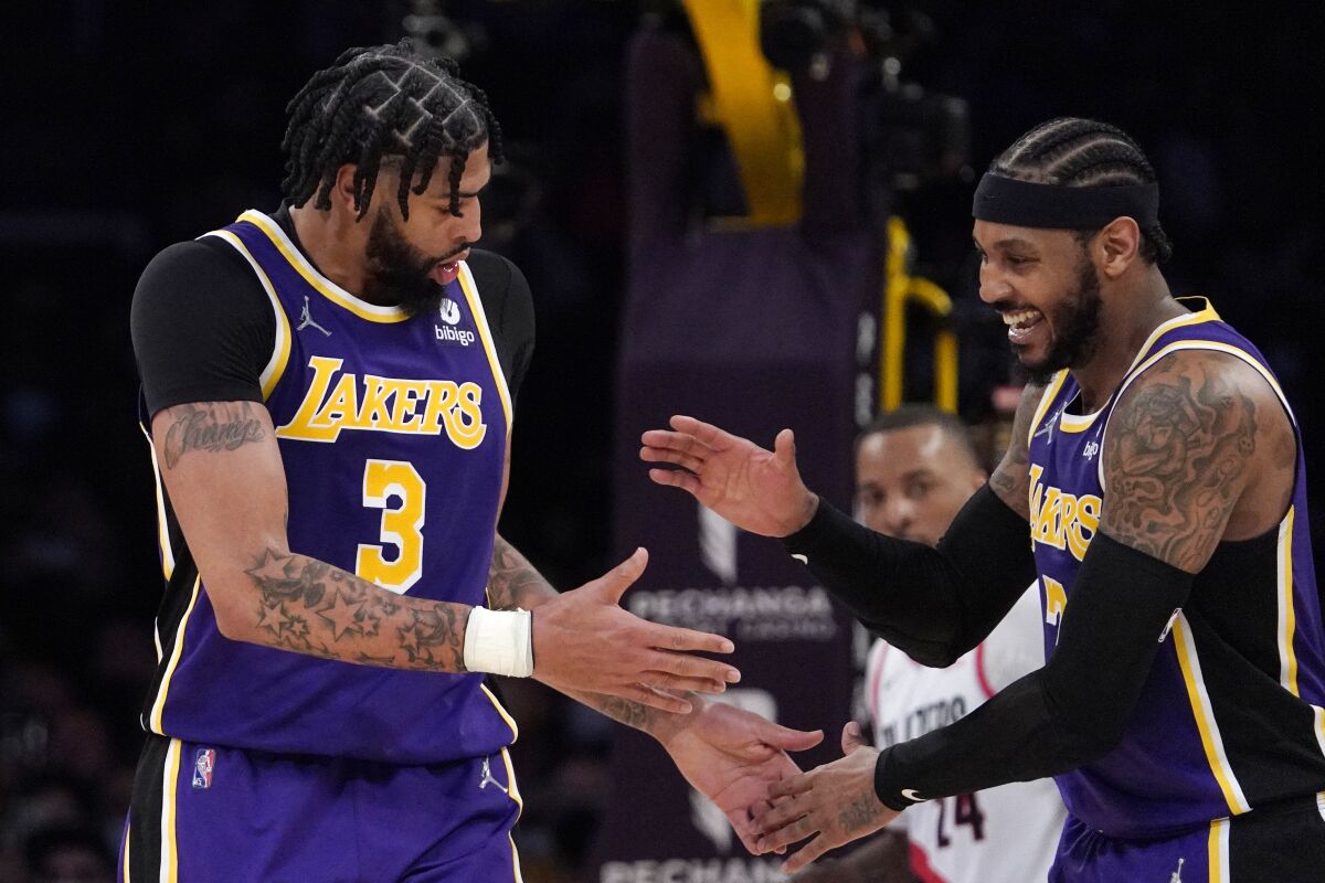 Los Angeles Lakers forward Anthony Davis, left, celebrates with forward Carmelo Anthony after scoring during the second half of an NBA basketball game against the Portland Trail Blazers Wednesday, Feb. 2, 2022, in Los Angeles. (AP Photo/Mark J. Terrill)