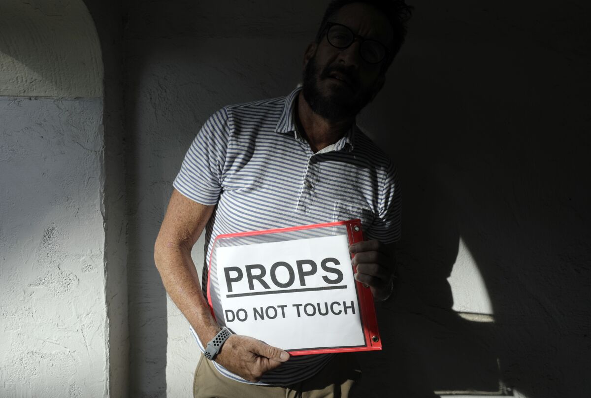 A man holds a sign that says, "Props. Do not touch."