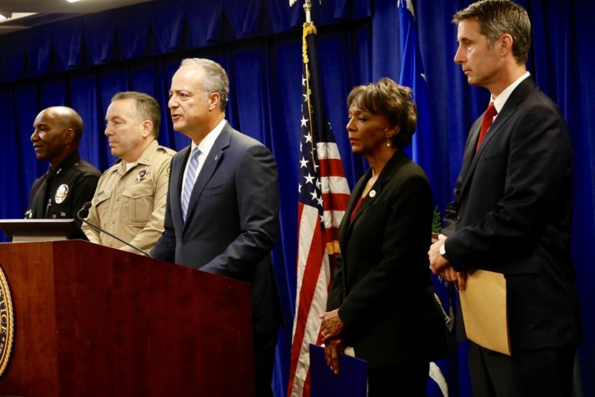 El fiscal Nick Hanna, al centro, anuncia una acusación contra miembros de la pandilla callejera MS-13 por una serie de ataques violentos en el área de Los Ángeles. (Al Seib / Los Angeles Times)