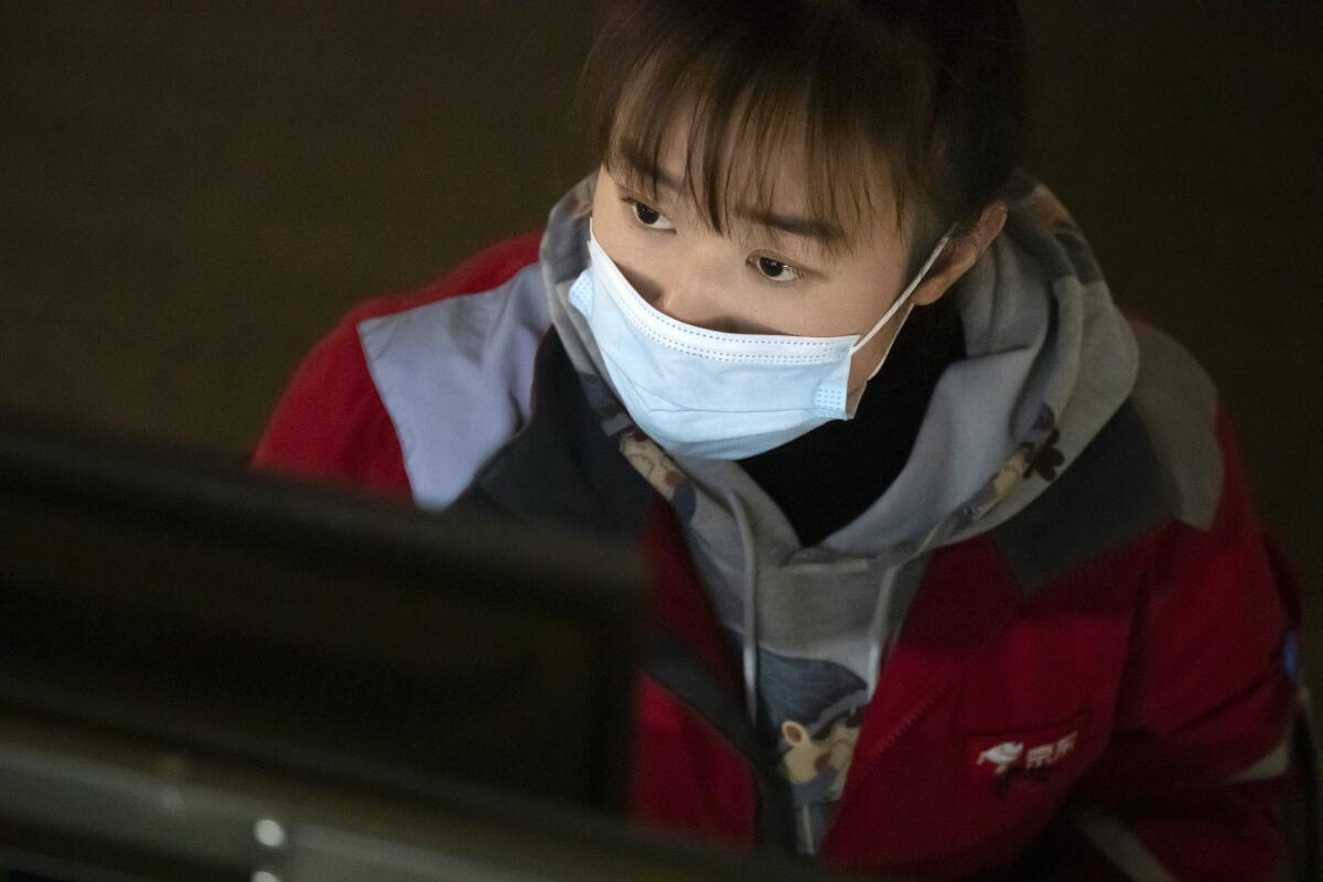 An employee looks at a computer terminal as she monitors an automated parcel handling line at a warehouse for online retailer JD.com in Beijing, Wednesday, Nov. 11, 2020. Chinese consumers spent over a hundred billion dollars during this year’s Singles’ Day shopping festival, signaling a rebound in consumption as China recovers from the coronavirus pandemic and a battering of the economy. (AP Photo/Mark Schiefelbein)
