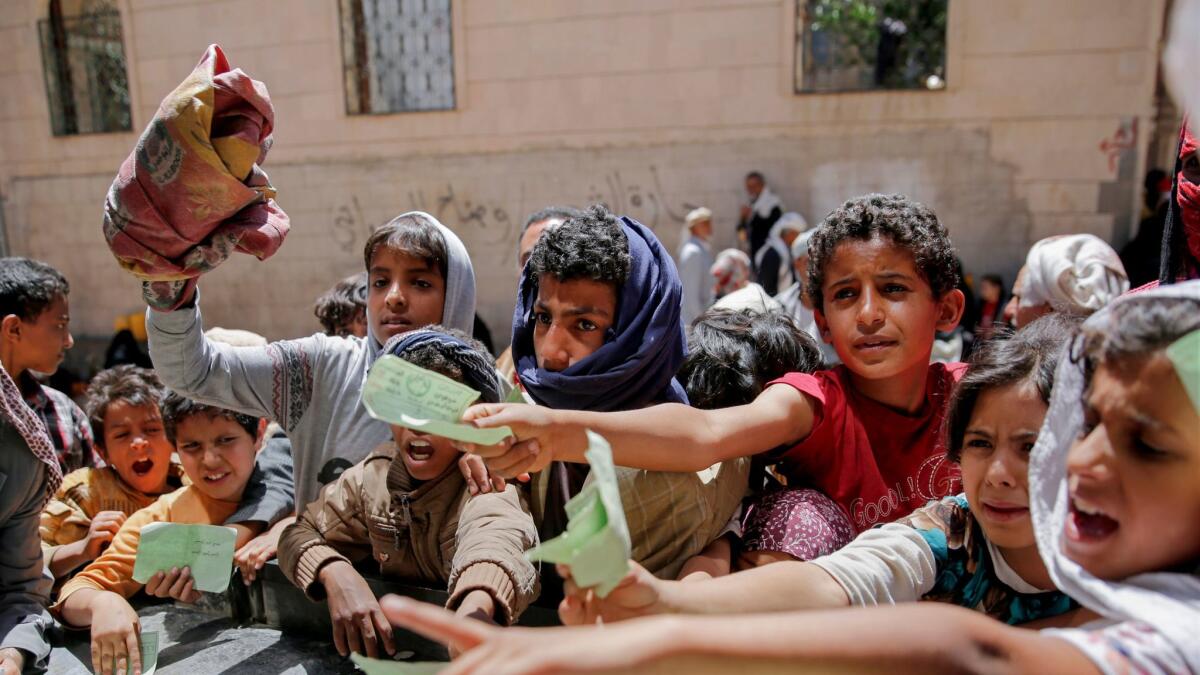 Yemenis present documents to receive food rations provided by a local charity in Sana, Yemen, in April.