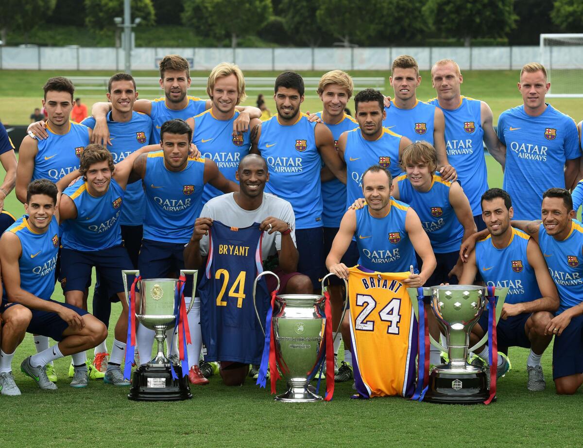 Lakers star Kobe Bryant poses with the FC Barcelona team after trading jerseys with Barcelona captain Andrés Iniesta Luján before a training session at the StubHub Center.