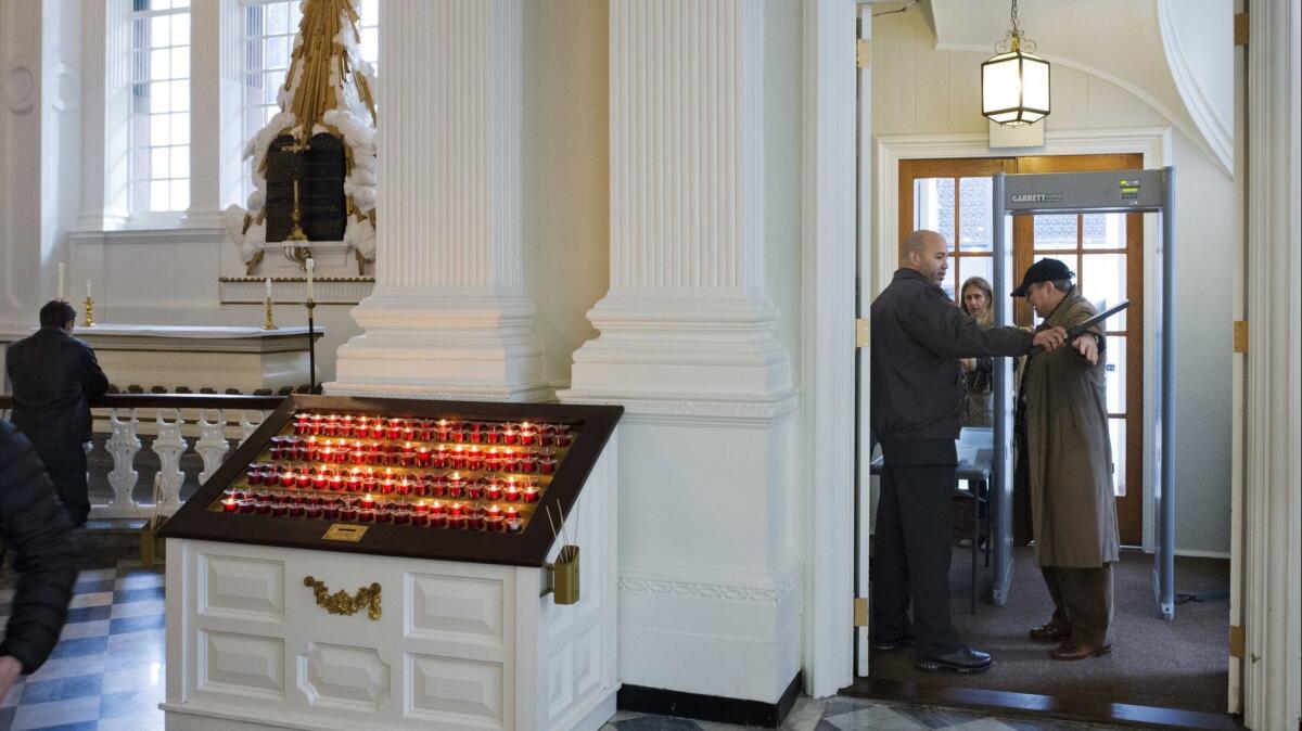 A security guard checks a visitor at the entrance to St. Paul's Chapel in New York.