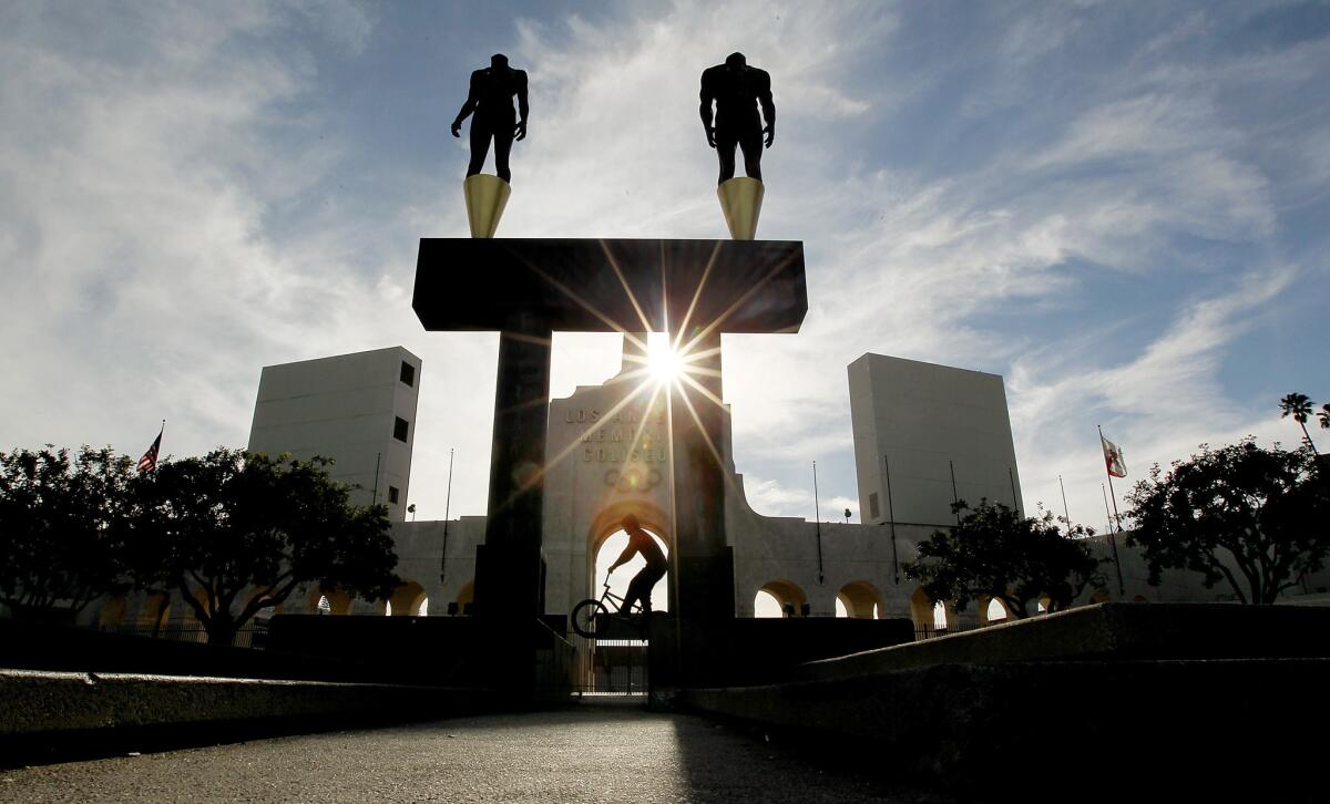 A bicyclist rides in front of the Los Angeles Memorial Coliseum on April 30.