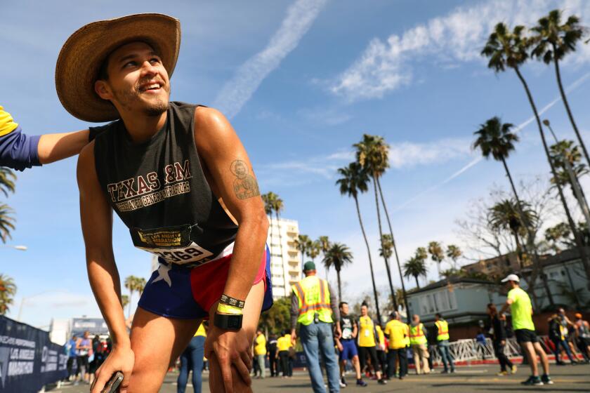 Race participant Jose Lara of Houston, Texas, catches his breath after finishing the L.A. Marathon on Sunday.