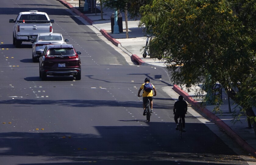 Bicyclists ride on 30th Street at University Ave.  