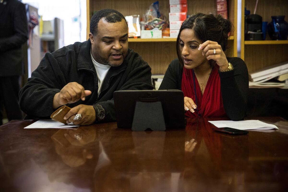Arthur Barrett, left, works with Sherin Jose of the Bronx Community Health Network to sign up for the Affordable Care Act, better known as Obamacare in New York City.