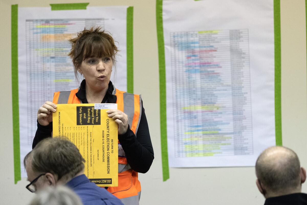 Kimberly Zapata, deputy director of the Milwaukee Election Commission, instructs workers processing ballots, Tuesday, April 5, 2022 at the central counting facility in Milwaukee, Wis. Zapata has been fired after sending falsely obtained military absentee ballots to the home of a Republican state lawmaker who has been an outspoken critic of how the 2020 election was administered, the city's mayor said Thursday, Nov. 3, 2022. (Mark Hoffman/Milwaukee Journal-Sentinel via AP)