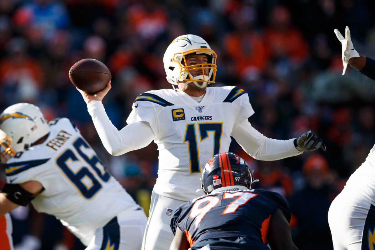 Chargers quarterback Philip Rivers throws a pass while under pressure from Denver Broncos linebacker Jeremiah Attaochu (97) during the first quarter on Sunday in Denver.