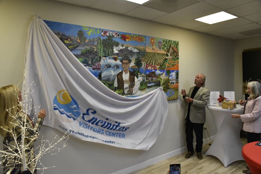Encinitas Chamber of Commerce Director of Membership and Community Relations Carol Knight and 101 Artists' Colony President Danny Salzhandler reveal the mural