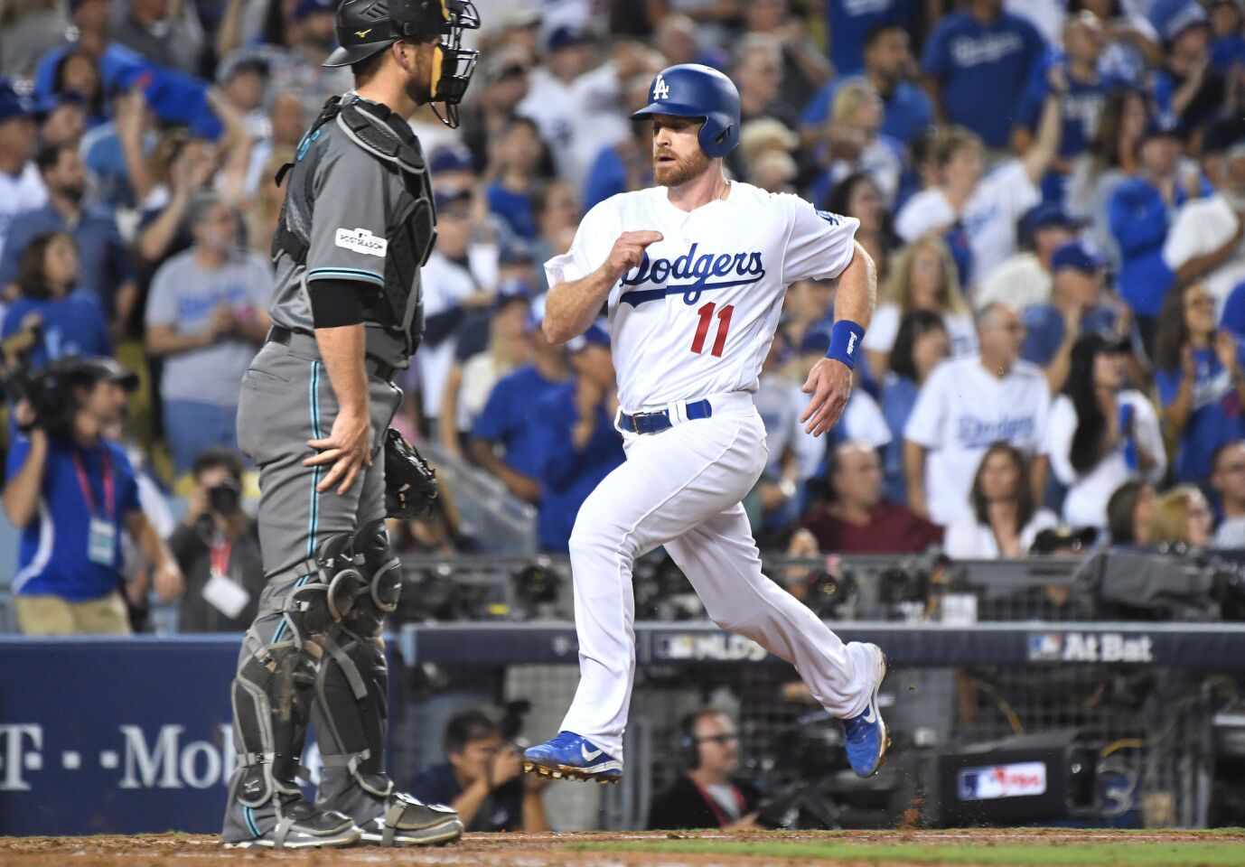 Dodgers second baseman Logan Forsythe scores in front of Diamondbacks catcher Jeff Mathis on a single by Corey Seager in the fourth inning in Game 1 of the NLDS at Dodger Stadium.